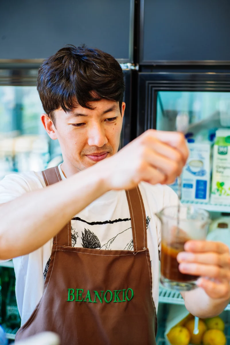 Barista préparant un café de spécialité derrière le comptoir d'un coffee shop