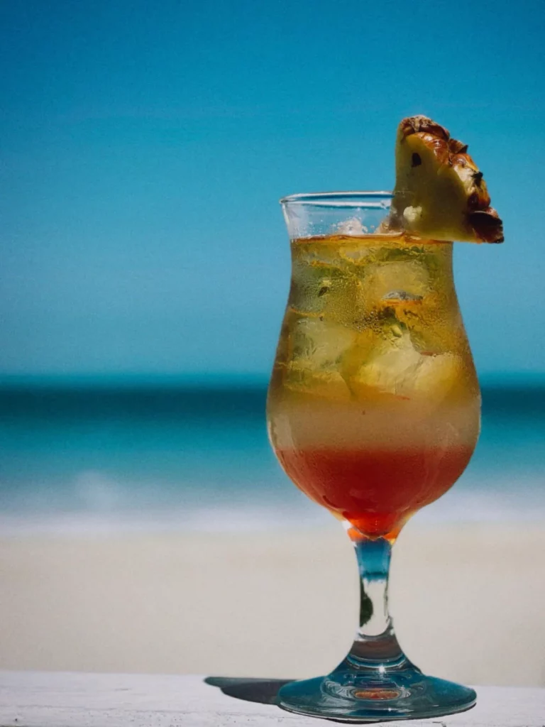 Cocktail tropical à l'ananas servi face à la mer, dans l'esprit du Painkiller de Pusser's