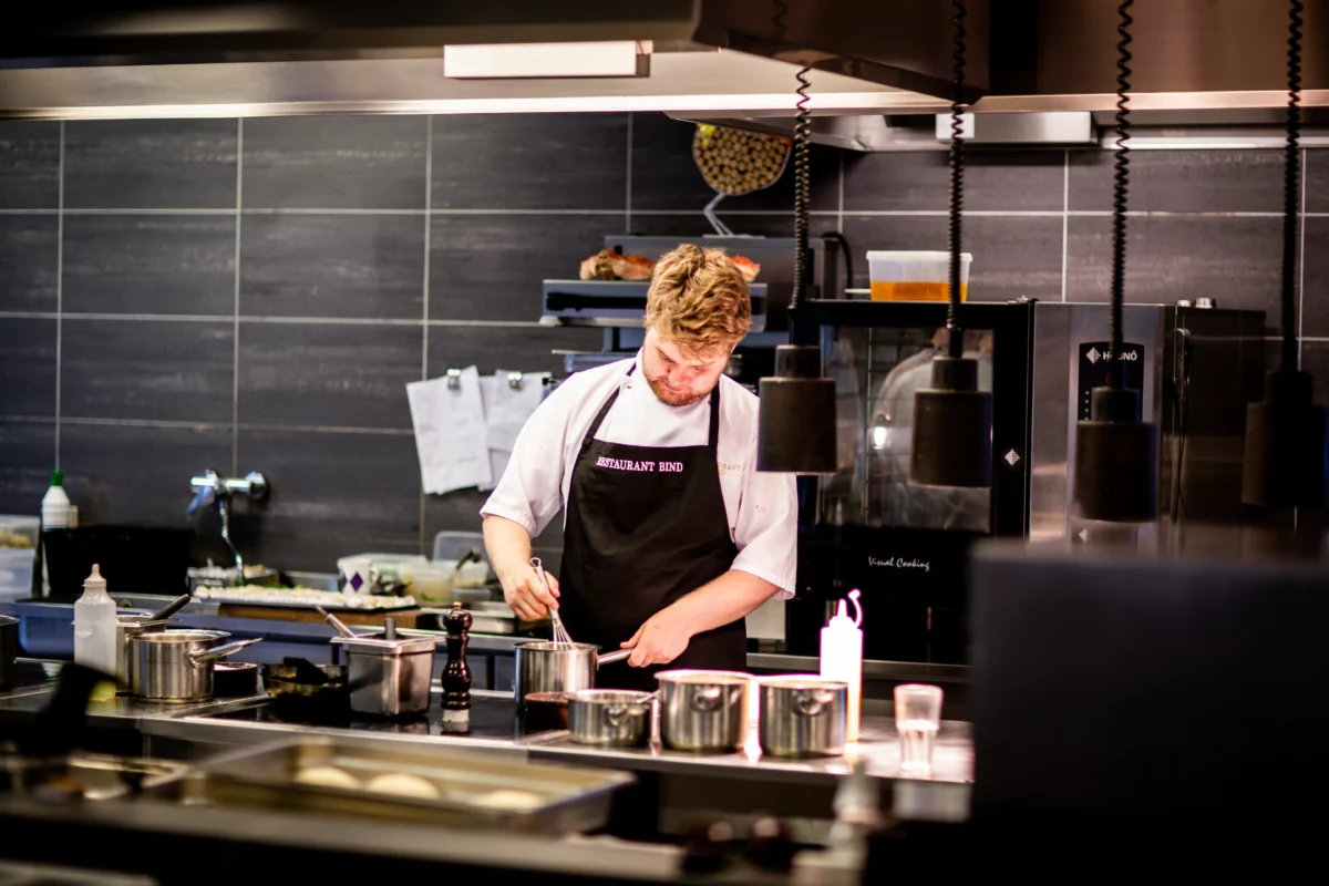 Chef en cuisine professionnelle en plein service, dans l'esprit du travail de Danny Horseele