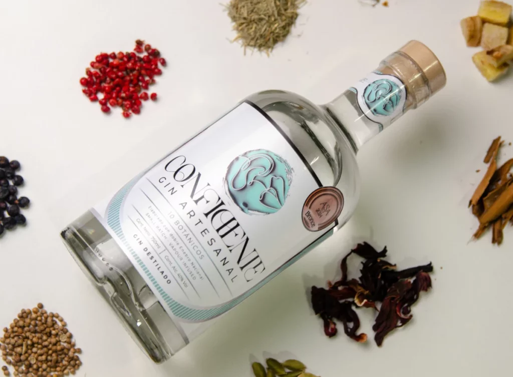 Bouteille de gin artisanal entourée de botaniques