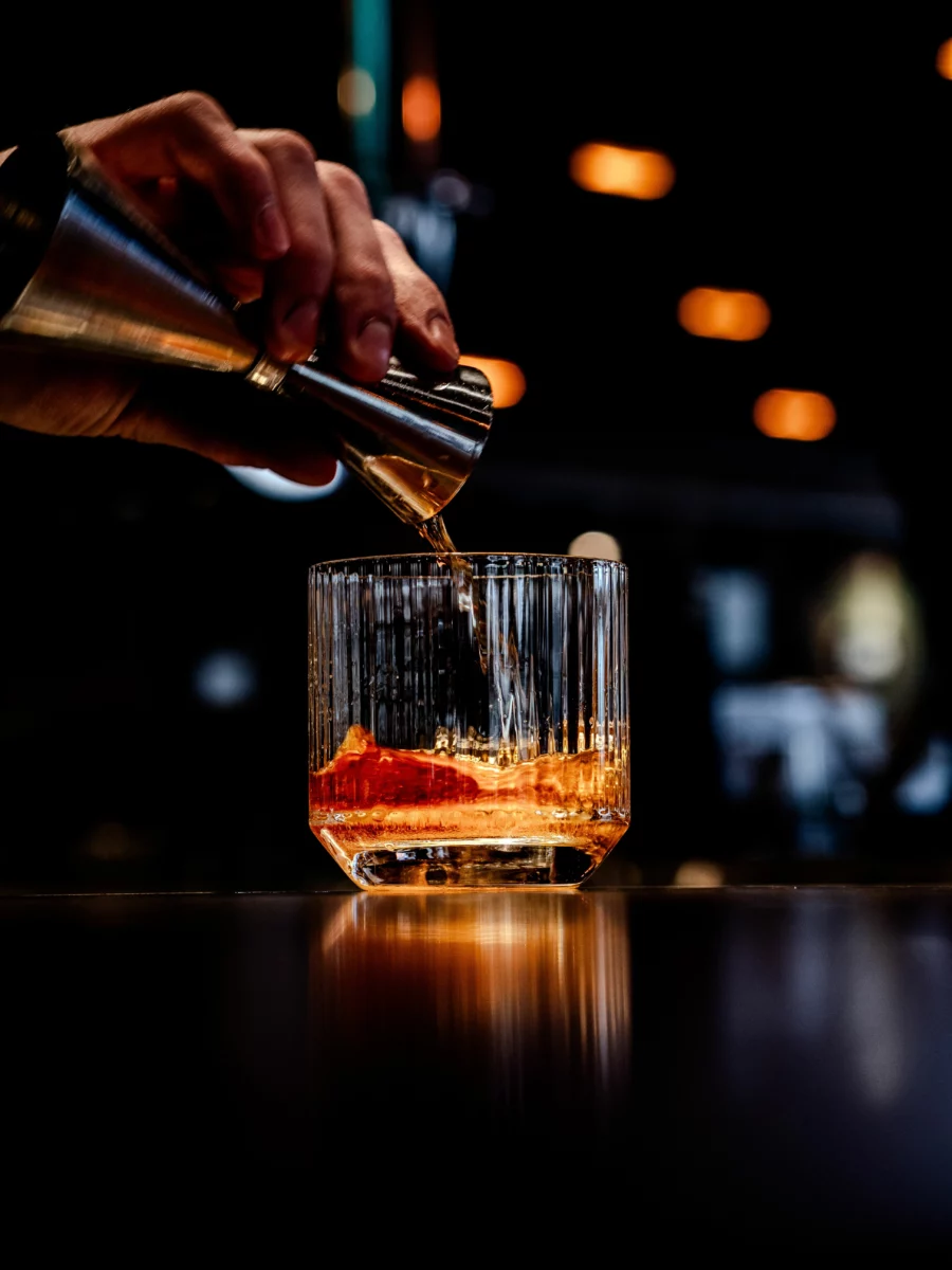 Cocktail ambré servi en coupe avec zeste de citron, dans l'esprit du Brandy Crusta