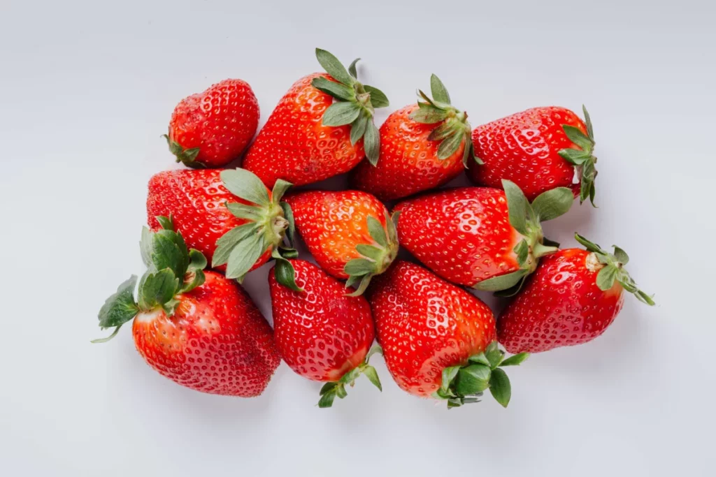 Fraises fraîches disposées sur fond clair, base du sirop fraise rose maison