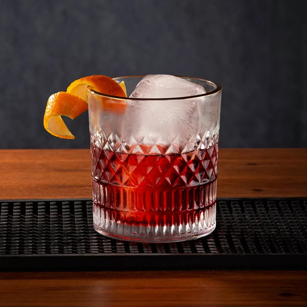 Cocktail Contessa servi sur glace avec un zeste d'agrume