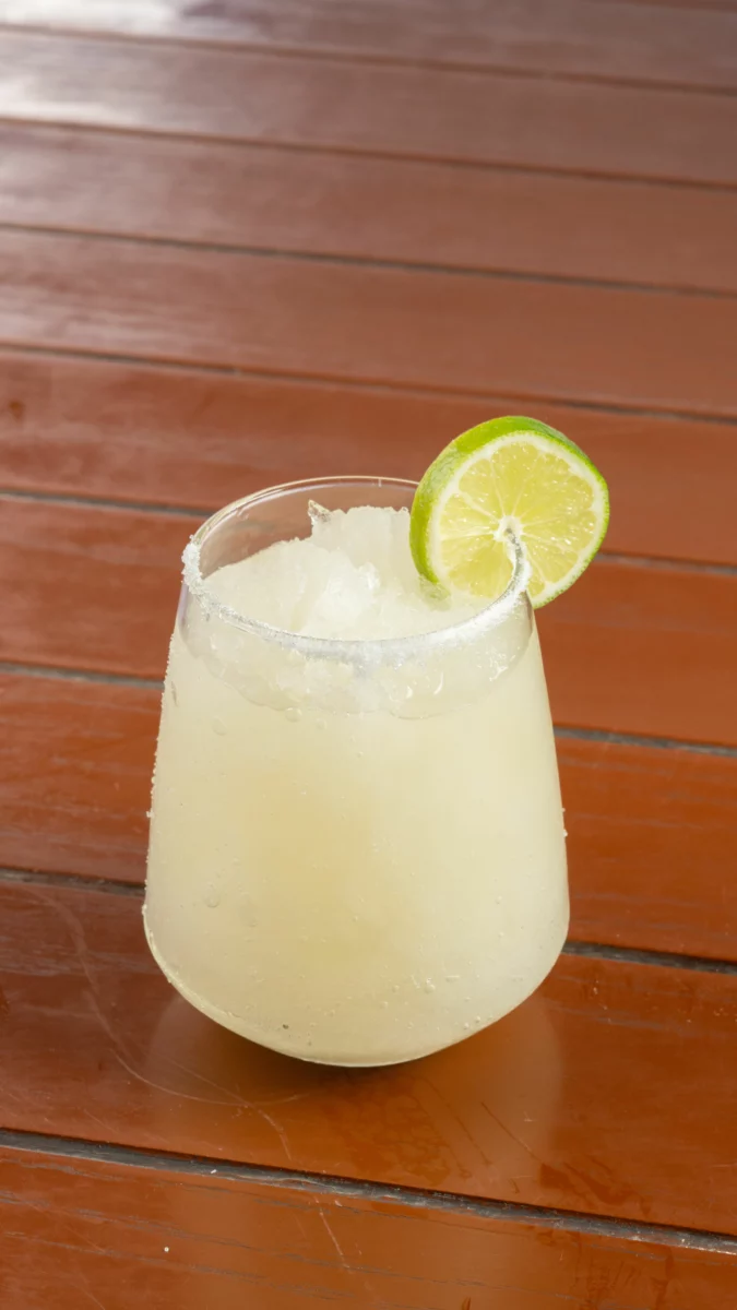 Margarita servie avec du citron vert sur une table en bois, base de la margarita au vin rouge