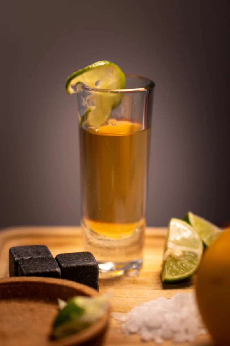 Verre de tequila añejo ambrée servi avec du citron vert