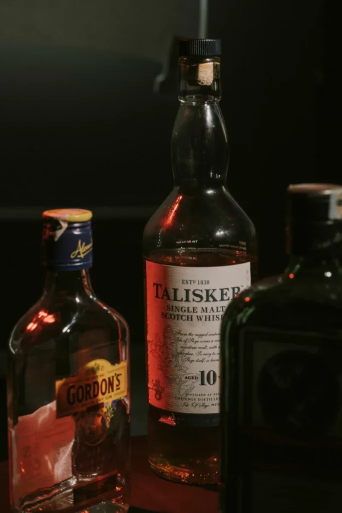Verres de whisky alignés sur un bar sombre, ambiance propice à l'Ardbeg Ardcore