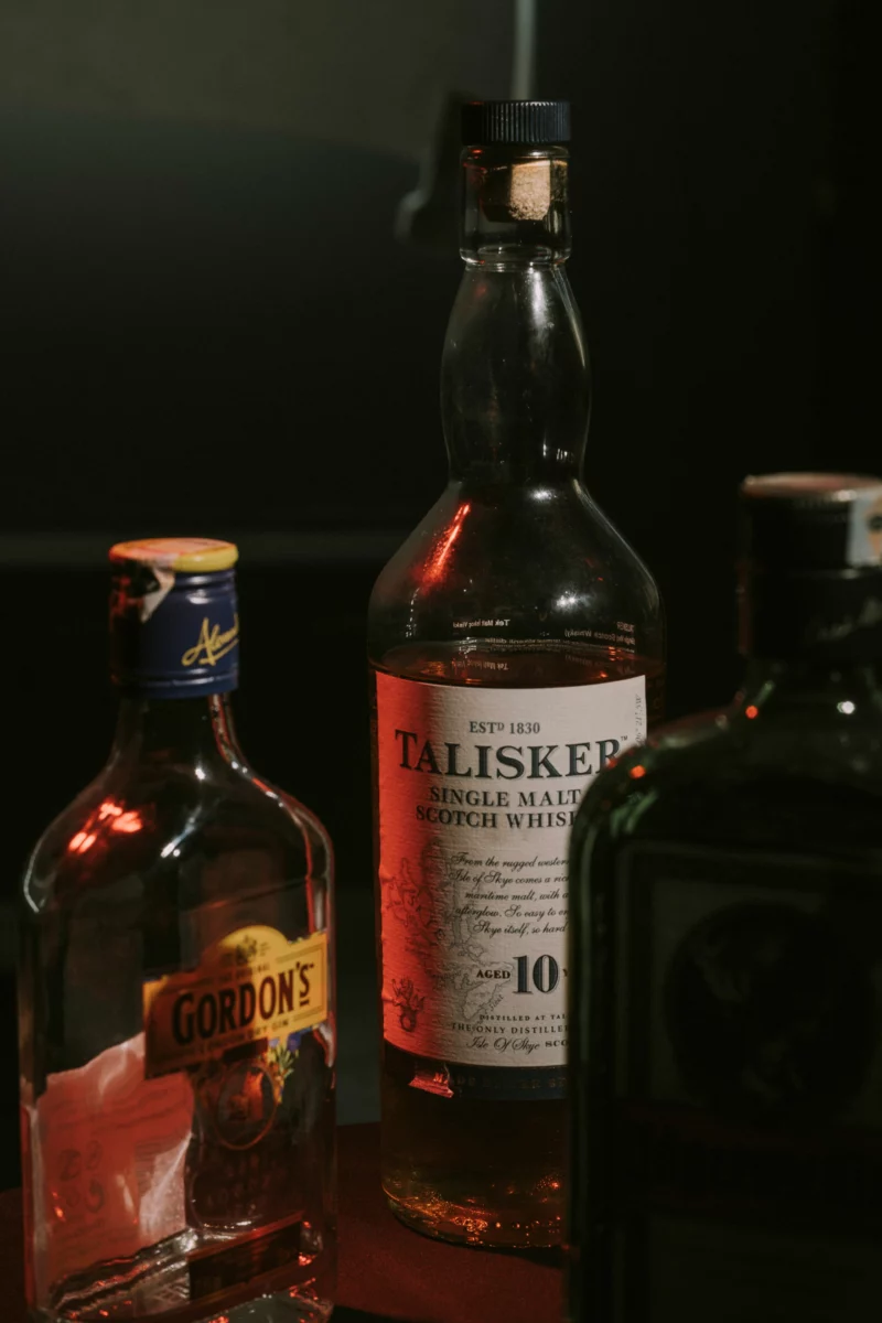 Verres de whisky alignés sur un bar sombre, ambiance propice à l'Ardbeg Ardcore