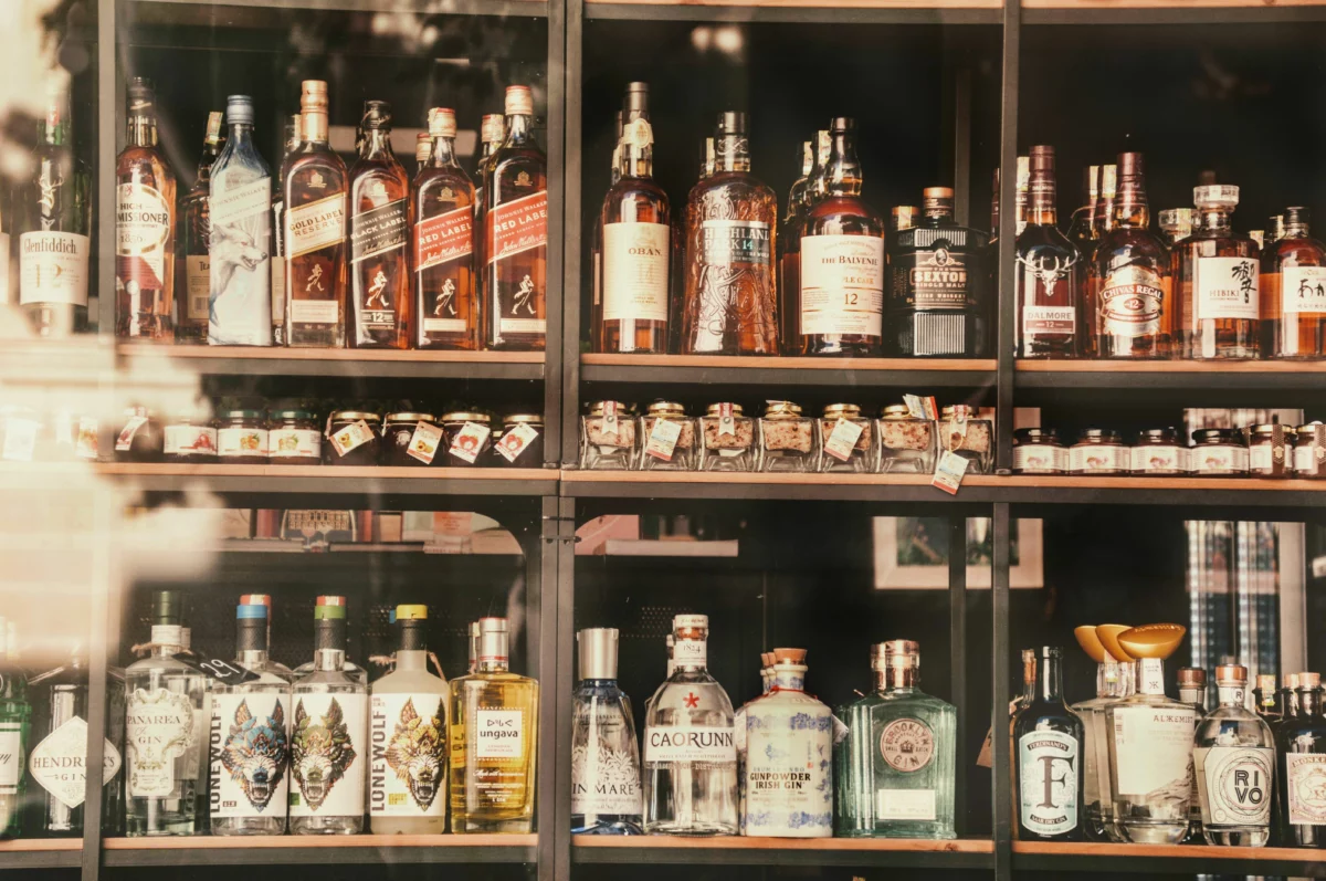Bouteilles de spiritueux alignées dans une lumière tamisée, illustration du livre Doctors and Distillers