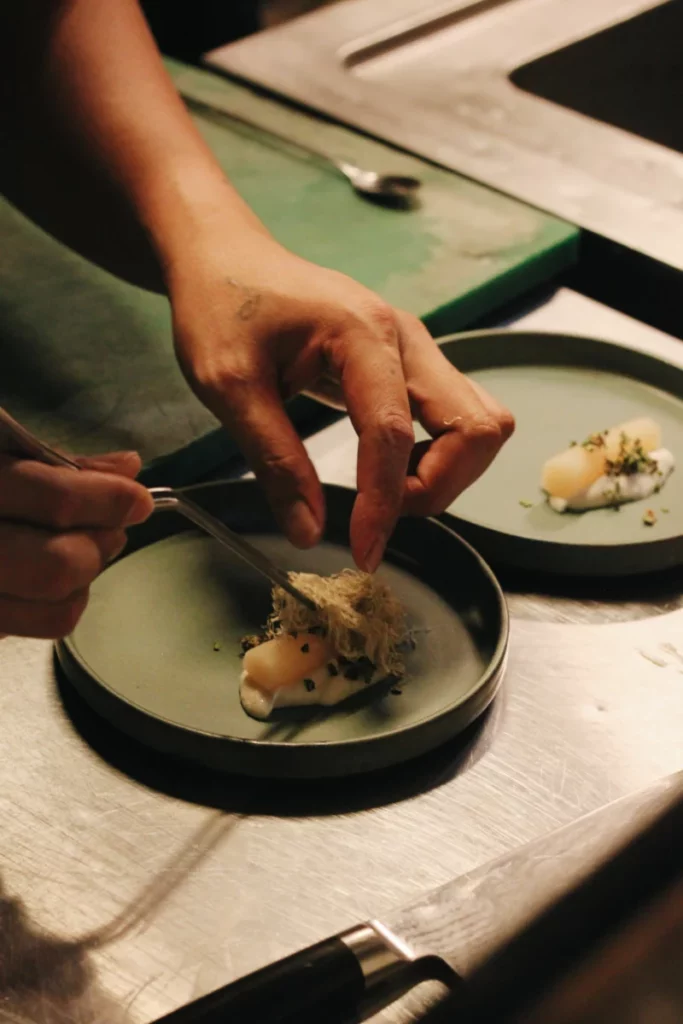 Chef dressant une assiette gastronomique, à la manière de Fabrice Vuillemin au Bel-Etage