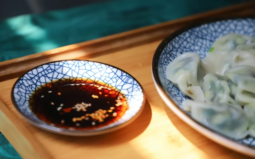 Coupelle bleue remplie de sauce brune fermentée, comme la sauce de poisson asiatique