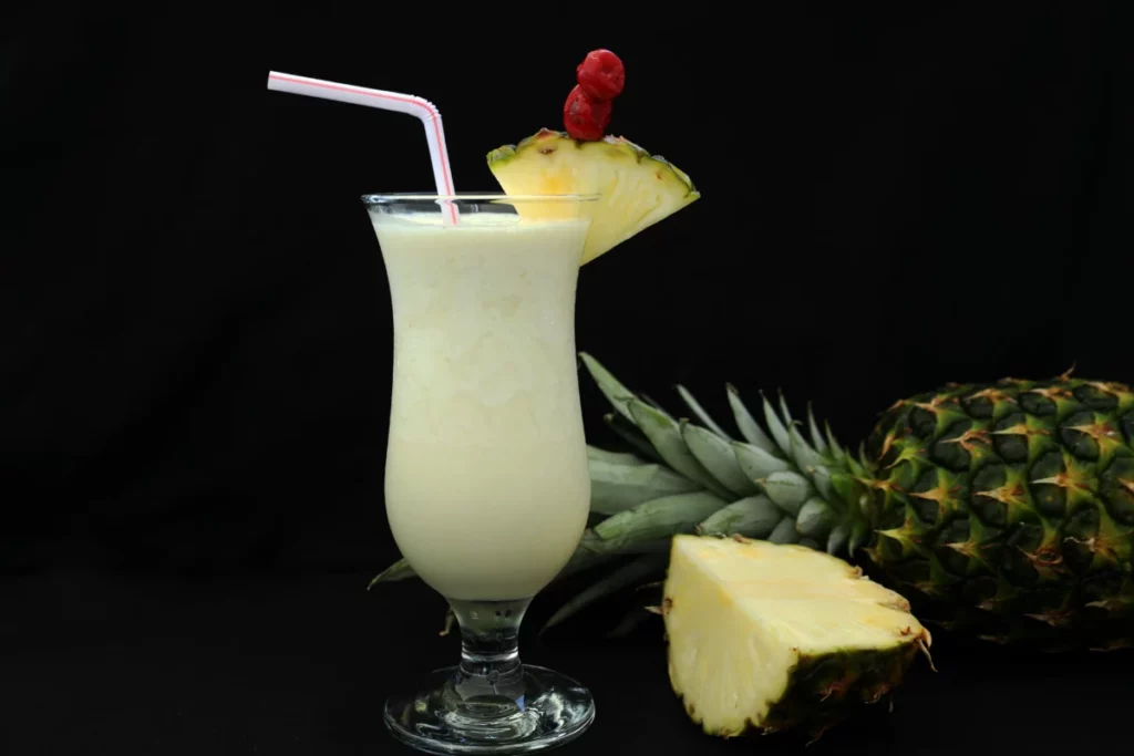 Verre de colada crémeuse garni d'ananas, base de la recette de Tequila Colada