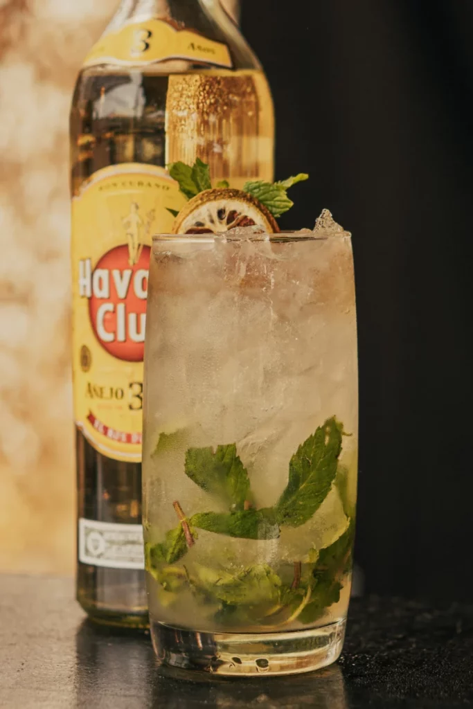 Bouteille de rhum et cocktail fraîchement préparé