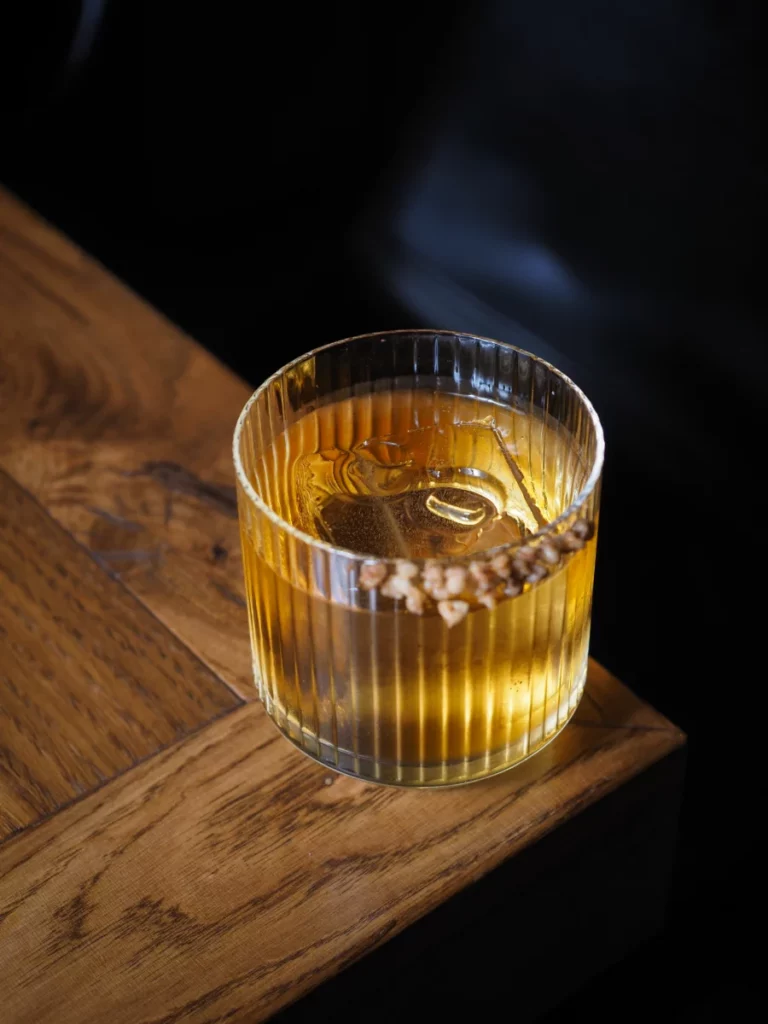 Verre de whisky posé sur une table en bois, comme ce Ben Nevis 20 ans de 1997