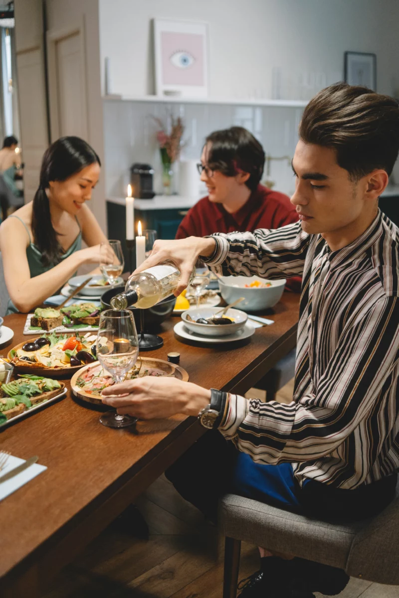 Groupe d'amis attablés avec des verres de vin, scène typique d'un dîner entre amis réussi