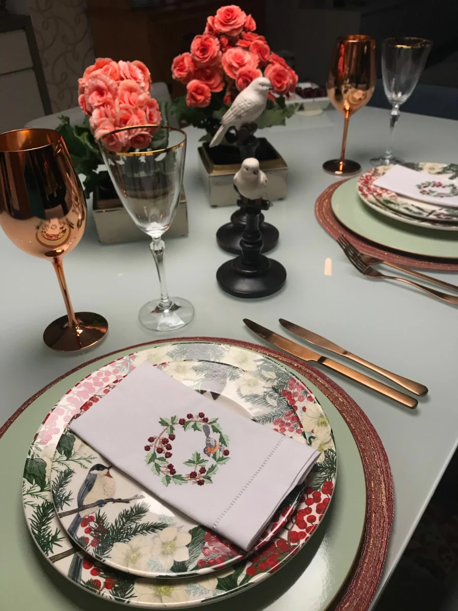 Table de restaurant gastronomique dressée avec assiettes fleuries et verres à vin