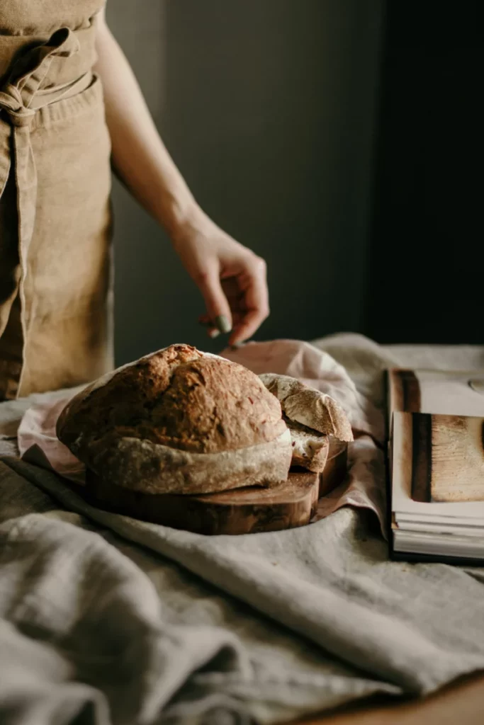 Miche de pain maison au levain posée sur une table en bois avec de la farine