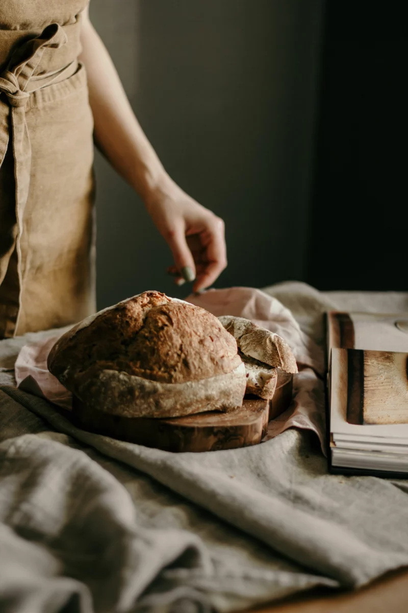 Miche de pain maison au levain posée sur une table en bois avec de la farine