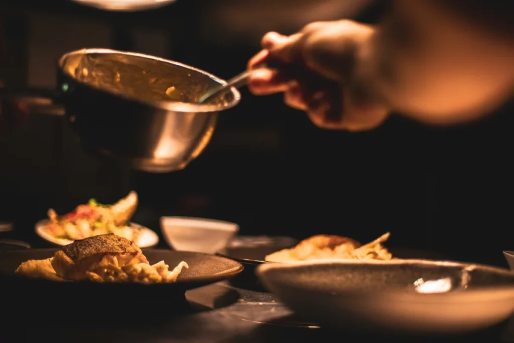 Cuisinier dressant un plat gastronomique, dans l'esprit de la table de Mario Elias au Cor de Chasse