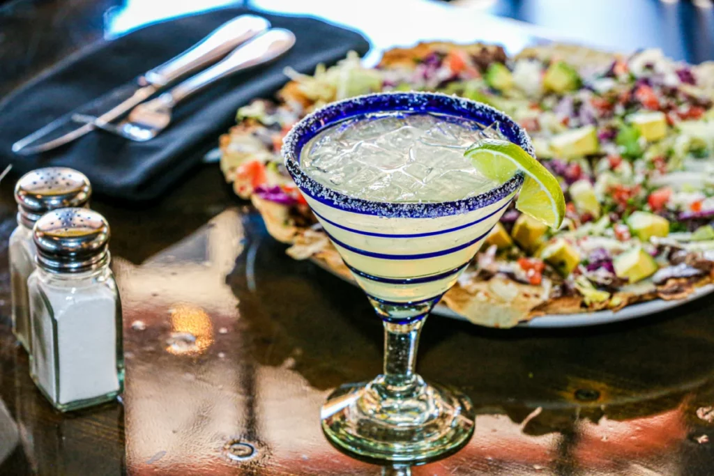 Verre à margarita givré de sel posé sur une table, prêt pour une freezer margarita