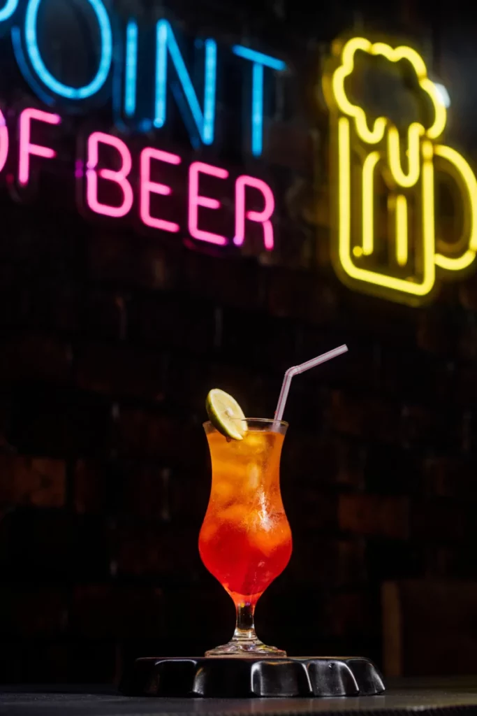 Cocktail servi dans un bar avec ambiance colorée