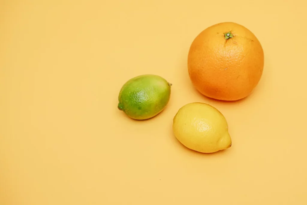 Citron jaune et citron vert posés côte à côte sur une table, le choix de base en cocktail