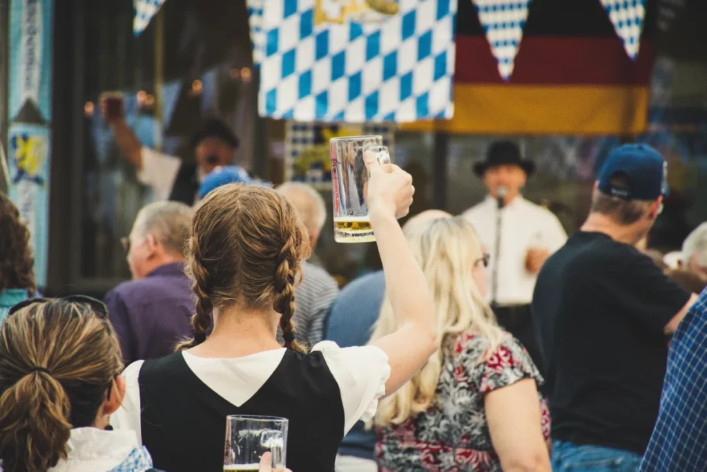 Femme levant un verre de bière dans la foule d'un festival de la bière