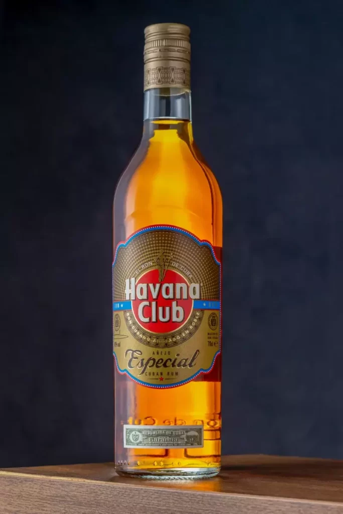 Bouteille de rhum antillais posée sur du bois, étiquette à vérifier pour un rhum AOC Martinique