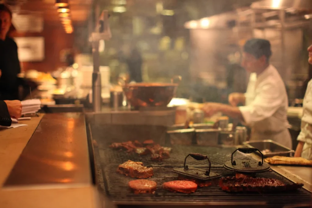 Chef en plein service dans une cuisine de restaurant, à l'image du travail de Jan Audenaert