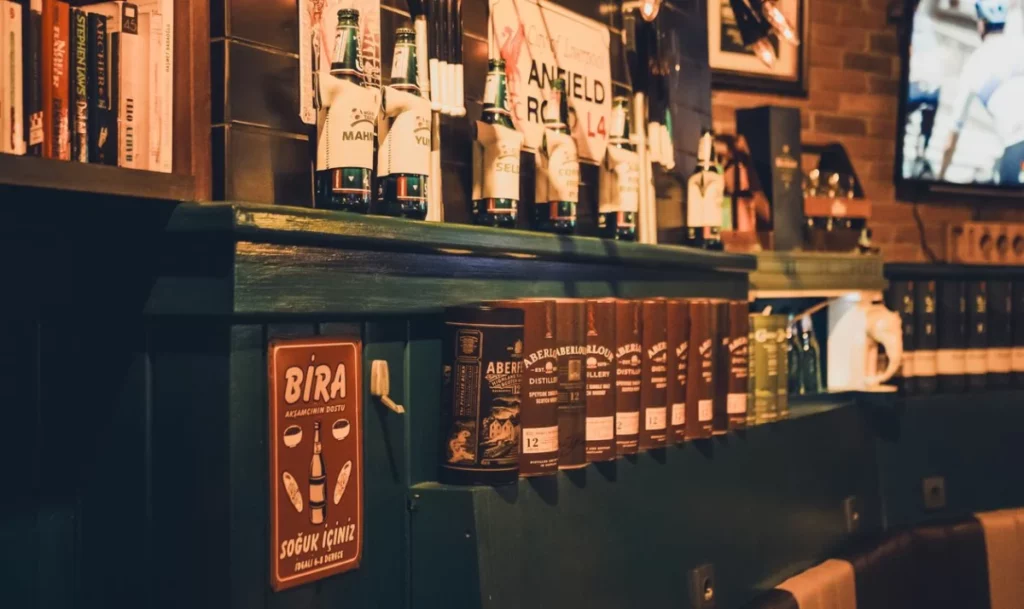 Interieur de bar chaleureux avec bouteilles et lumiere tamisee, illustration de l'actu boissons de la semaine