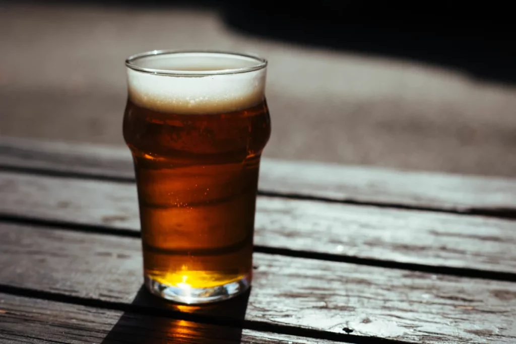 Verre de bière blonde fraîche en terrasse l'été, illustrant la nouvelle bière Pilou