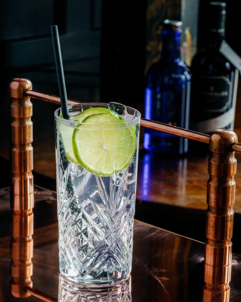 Verre de cocktail tropical avec paille, évoquant la douceur fruitee du rhumum Lamb’s Palm Breeze