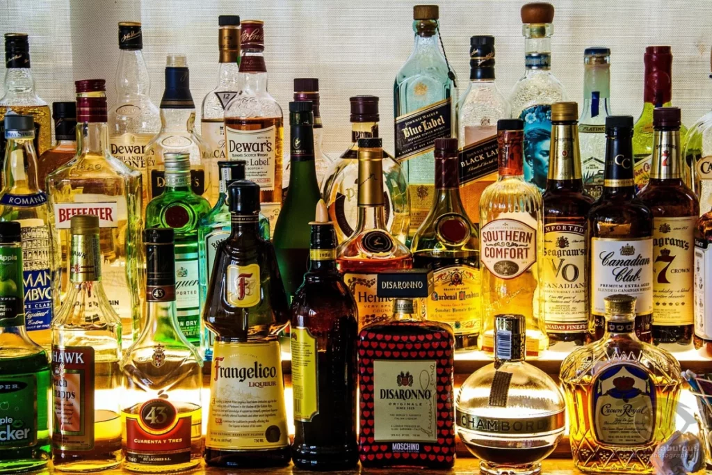 Bouteilles de spiritueux alignées sur une étagère de bar