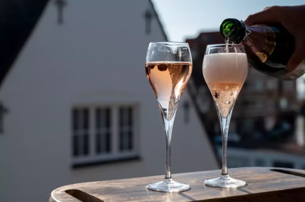 Coupes de champagne servies en terrasse pour un pique-nique estival, illustration de la campagne Picnic by Veuve Clicquot