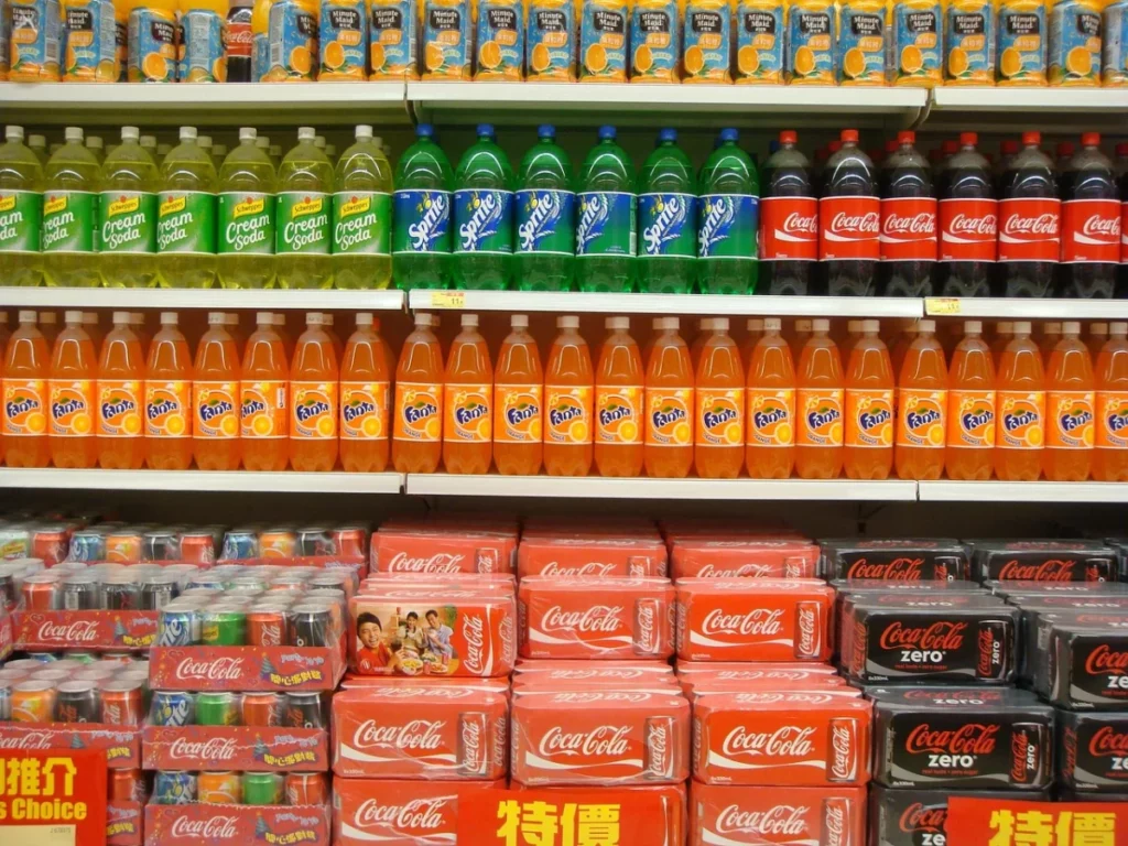 Bouteilles de soda alignées sur une étagère de supermarché