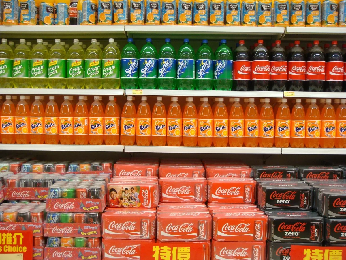 Bouteilles de soda alignées sur une étagère de supermarché