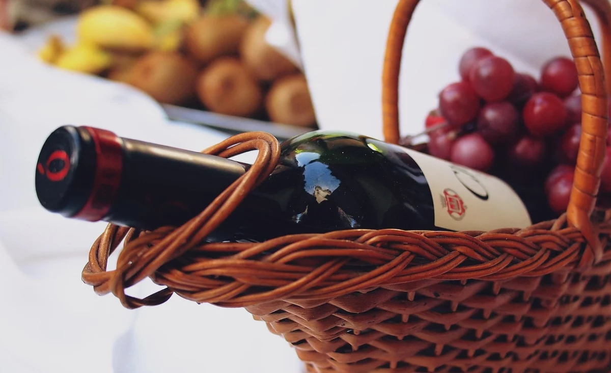 Bouteille de vin accompagnée d'une grappe de raisin