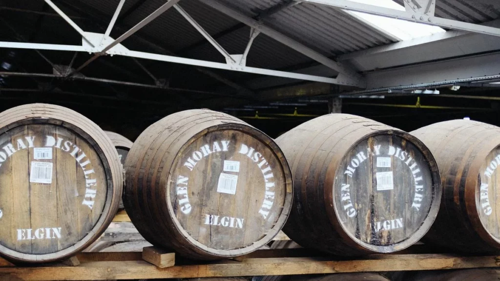 Fûts de chêne alignés dans un chai de distillerie écossaise, univers du whisky Bruichladdich Greener Still