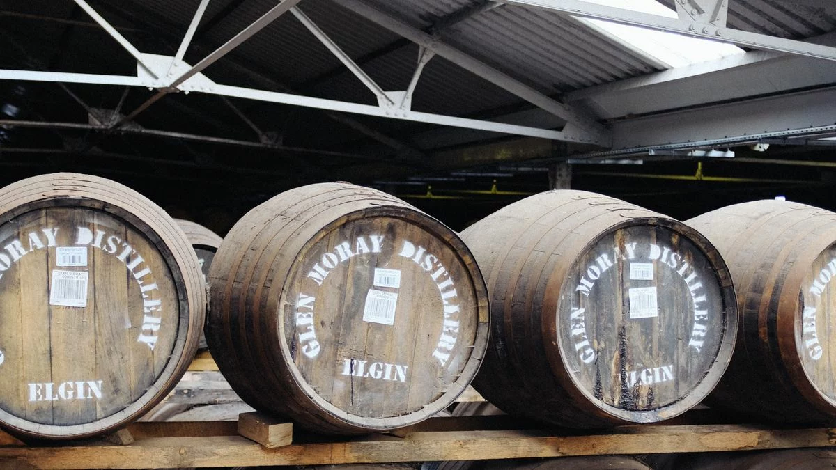 Fûts de chêne alignés dans un chai de distillerie écossaise, univers du whisky Bruichladdich Greener Still