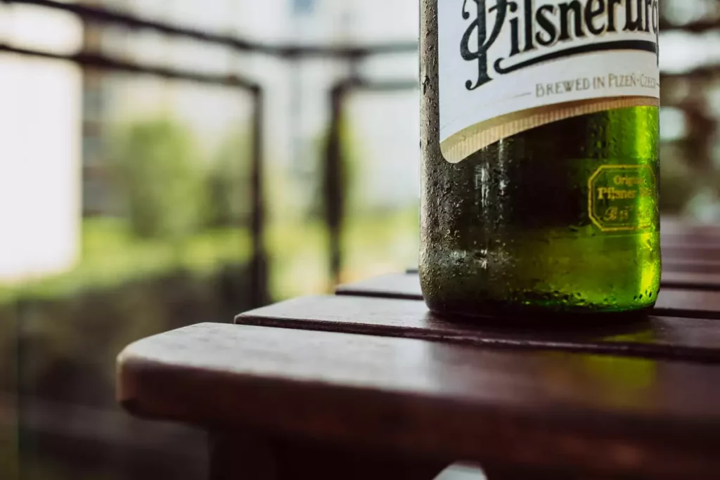 Bouteille de bière fraîche sur une table de terrasse ensoleillée, illustration du lancement de la bière sans alcool Bud 0.0