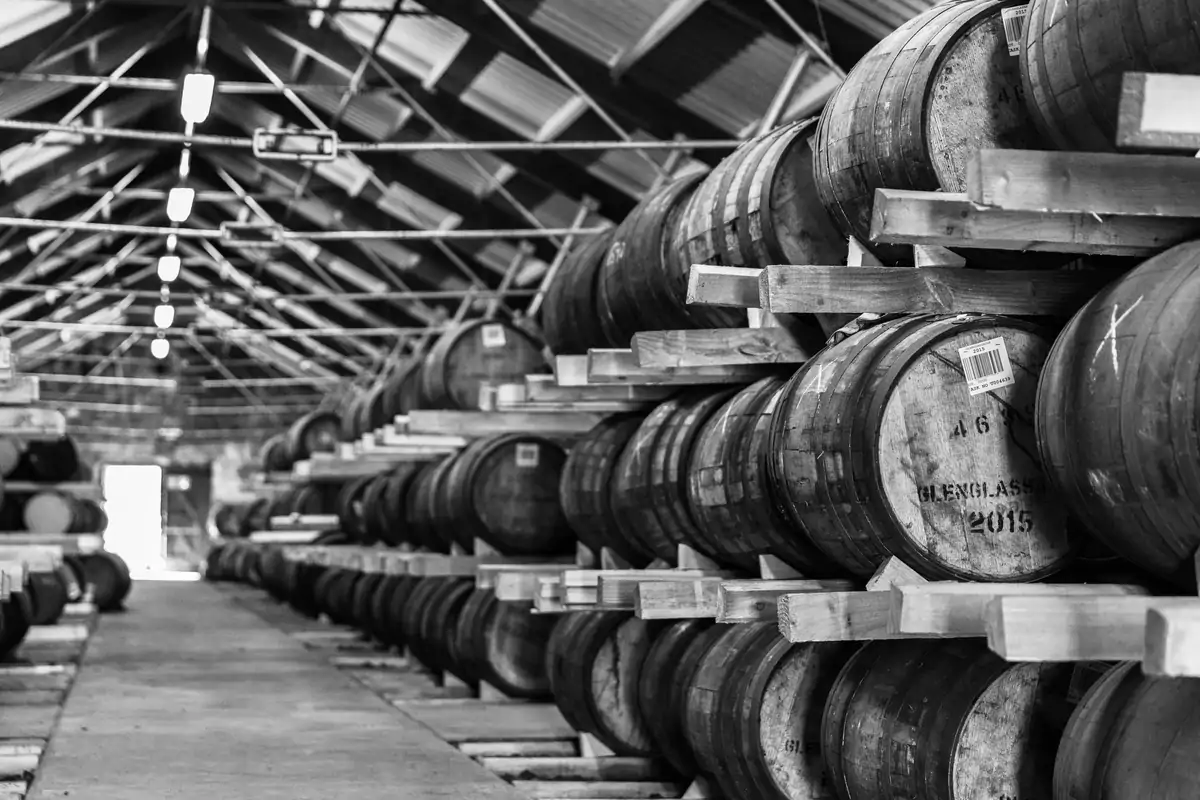 Fûts de chêne empilés dans un chai écossais, comme les cinq types de fûts du Glenfiddich Aston Martin