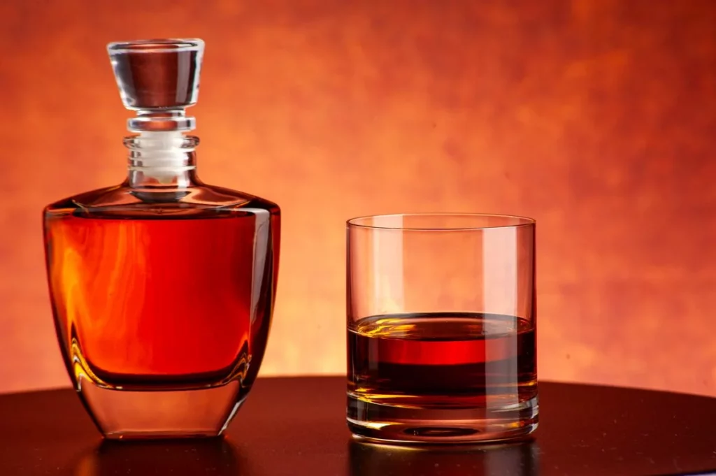 Carafe et verre de whisky ambré posés sur un fond chaleureux, dans l'esprit du Glenfiddich Military Tattoo 2026