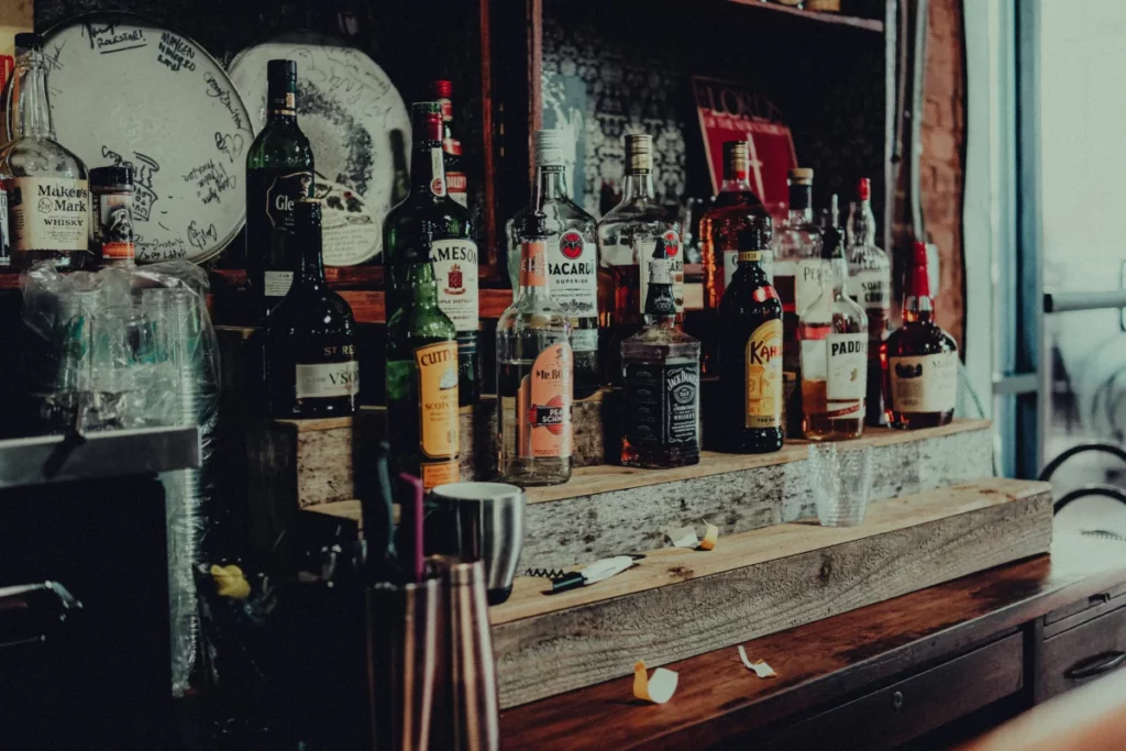 Bouteilles de spiritueux alignées sur une étagère de bar en bois - Spiritives Bordeaux 2026
