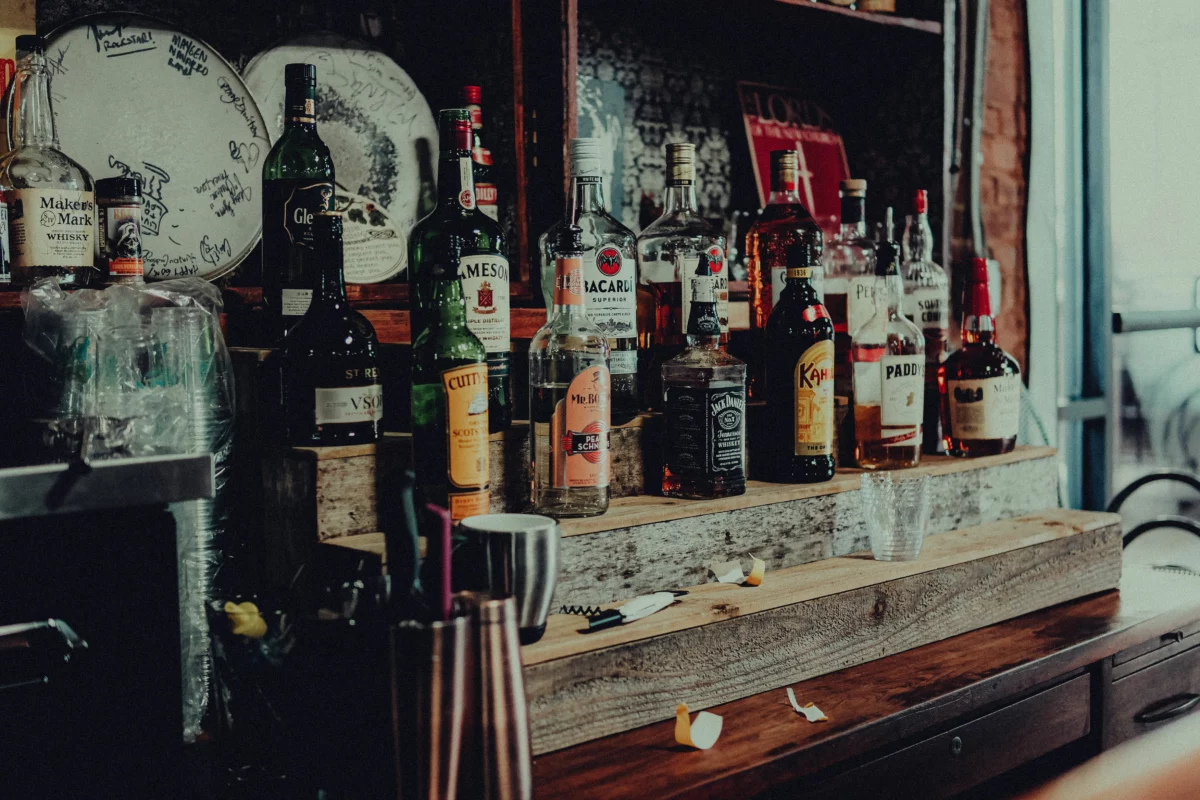 Bouteilles de spiritueux alignées sur une étagère de bar en bois - Spiritives Bordeaux 2026