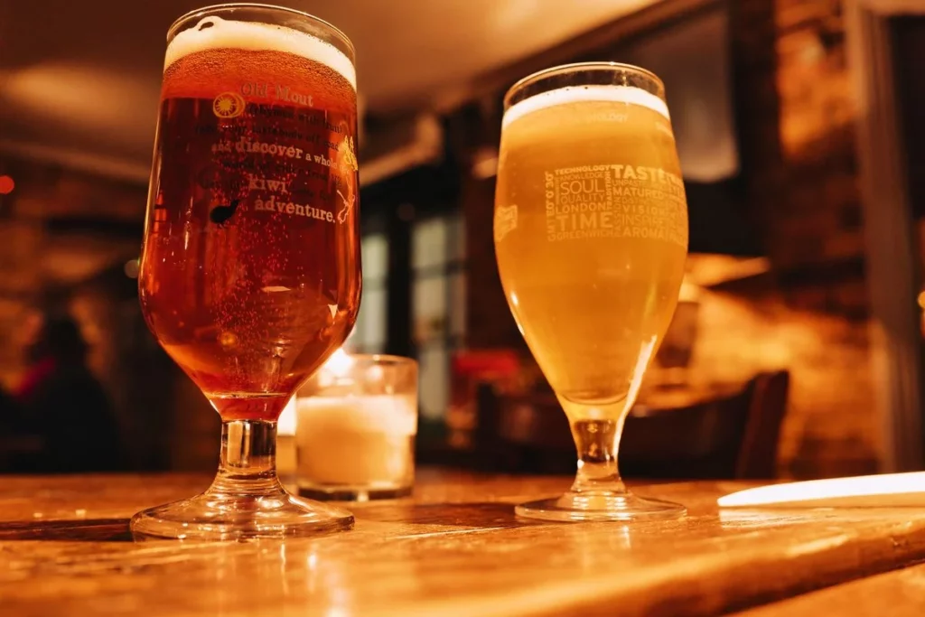 Bar chaleureux avec deux verres de biere bud sans alcool poses sur une table en bois